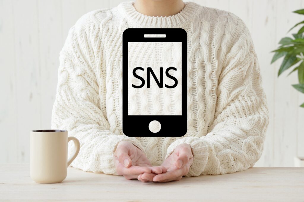 SNSと表示されたスマホのピクトグラムと女性